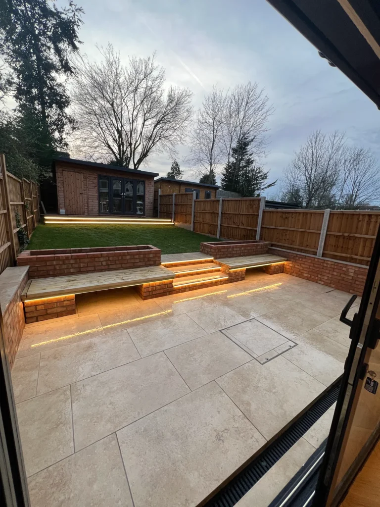 Modern multi-level terraced garden layout featuring custom brick retaining walls, built-in planters, and integrated timber bench seating.